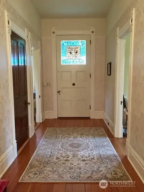 Huge, original 10 ft front door. Doorway to the left is a den/office.  Doorway to the right is the living room. Closed door leads to the upstairs.