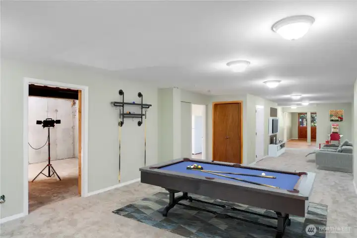 Spacious room ideal for a game, media, or video game room, conveniently next to the lower kitchen, with an adjacent unfinished space perfect for dry storage or a wine cellar.