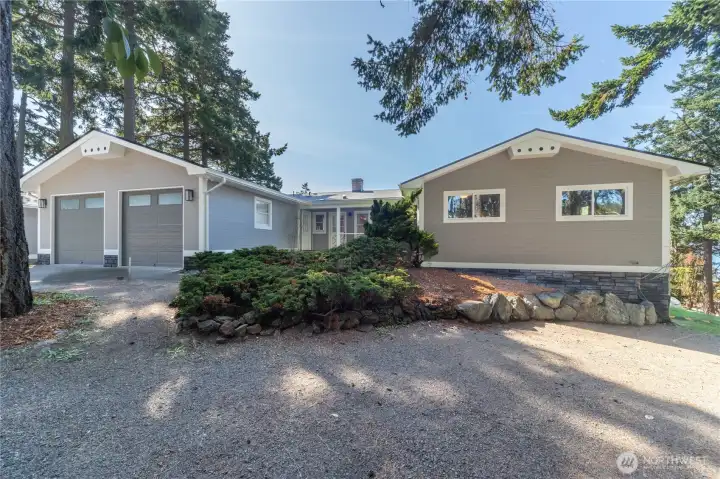 The view from the front of the house. There is a covered deck in the front. There is a large two car garage with 220V hookup and plenty of parking.