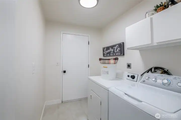 Laundry room off garage and hallway features new Duralux flooring.