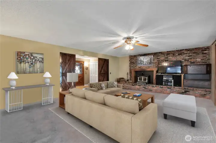 Large Living room with brick wall and wood burning fireplace insert.