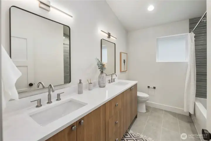 Guest bathroom includes double vanity with plenty of storage and cool light fixtures