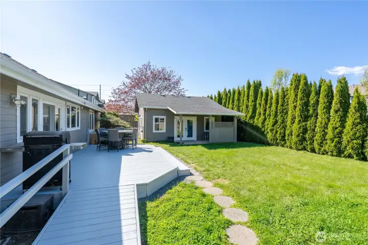 Back deck with ramp access and private back yard with detached studio/shop building.