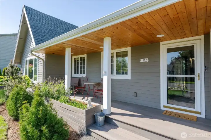 Charming front porch with 'Trex' like decking, new pine wood panel ceiling, new lighting and a raised bed to show off your bulbs, annuals etc. Relax on your sheltered south facing porch both summer and winter.
