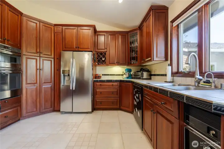 Beautiful kitchen overlooks the deck. Stainless steel refrigerator, convection oven, convection microwave, natural gas cook top from DeWaard & Bode. Solid cherry wood cabinets, new bronze lighting, stainless double sink and faucet, Insta-Hot. Kitchen also has dishwasher and compactor.