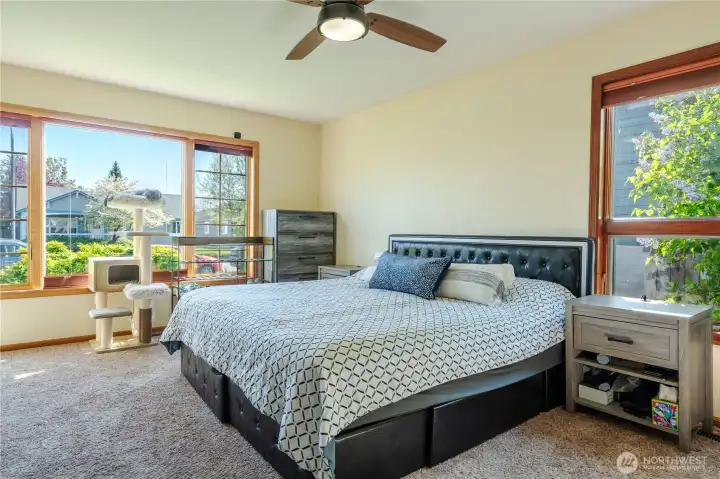 King size primary bedroom with seating area faces front yard.  Includes cellular blinds with blackout on the inside of blinds.