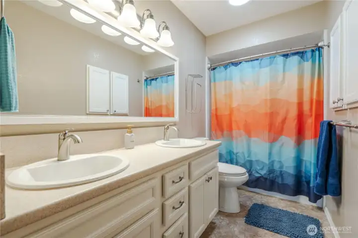 Main bathroom with double sinks and bathtub.