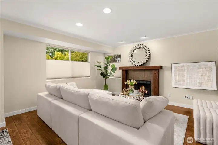 Bright living room featuring a wood-burning fireplace and large windows