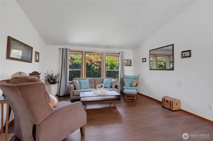 Living room with continuous wood flooring and wall of windows