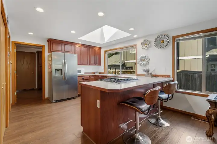 Kitchen heading to laundry room and garage, skylight lets the sunshine in
