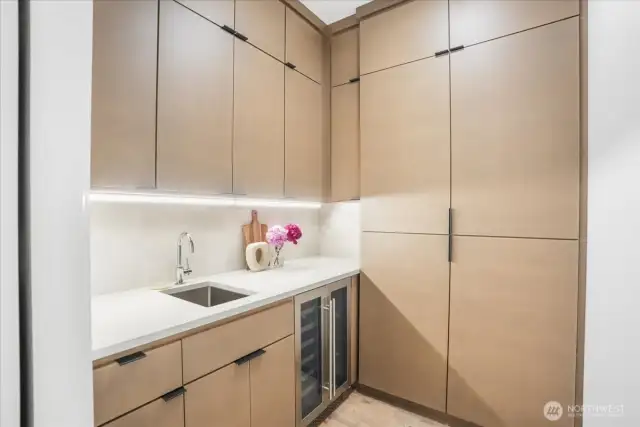 Complete walk-in Butlers Pantry w/ cleaners sink, built-ins & wine fridge