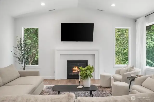 Open living room w/ vaulted ceilings & large windows for natural lighting