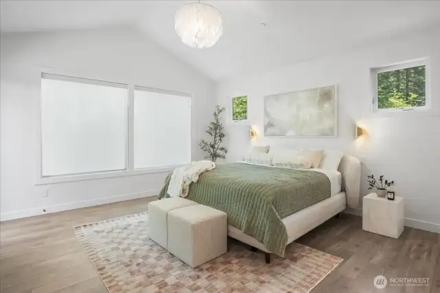 Vaulted ceiling primary bedroom on the main equipped w/ motorized blinds & a door to the your upper deck