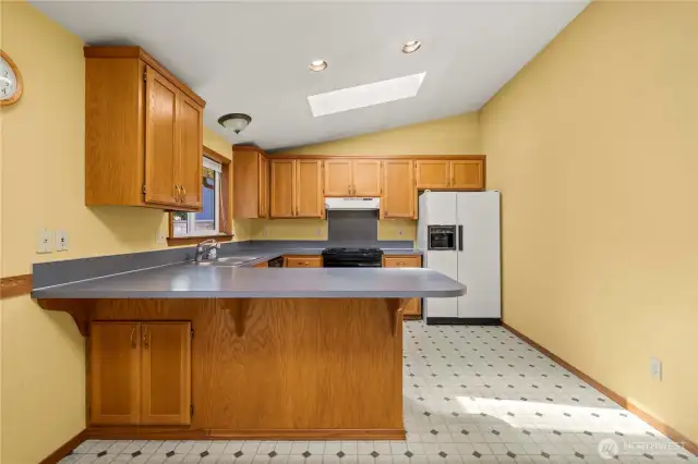The kitchen has an eating bar as well as the dining room space behind it.