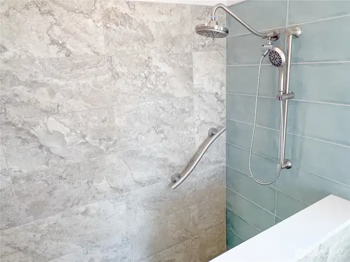 Practical two headed shower with ergonomic grab bar.