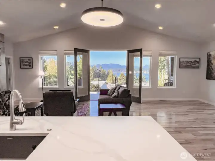 French doors & large windows welcoming the outdoor beauty in. Generous space to the right of the couch for your "dining with a view" pleasure.