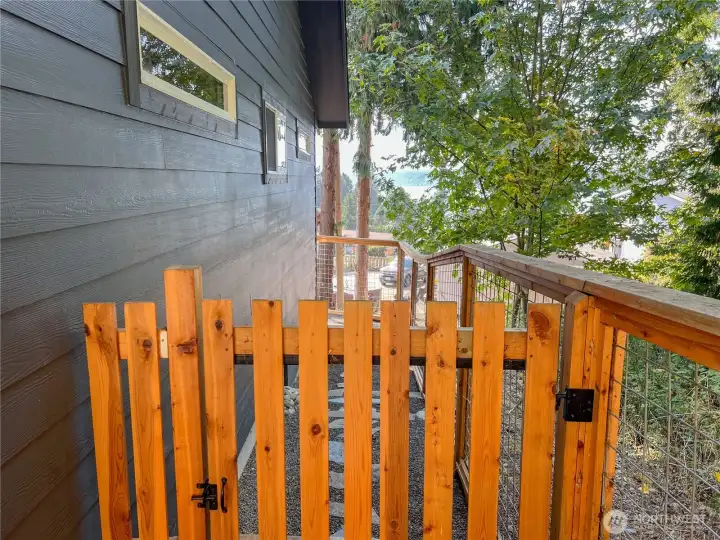 Fenced-in dog run on the far side of the house that wraps around to the back deck.