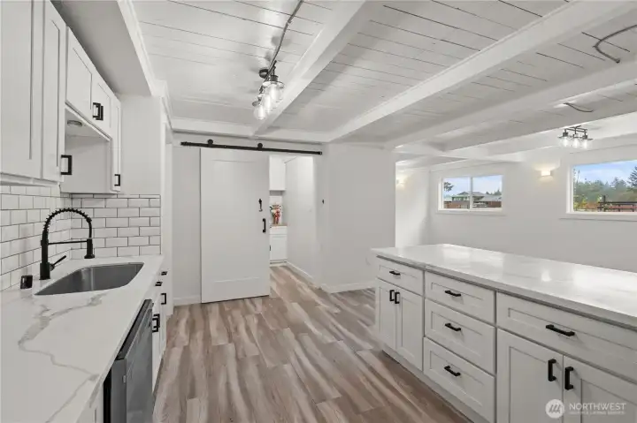 Kitchen with bar seating,  new stainless steel appliances and a large butler's pantry.