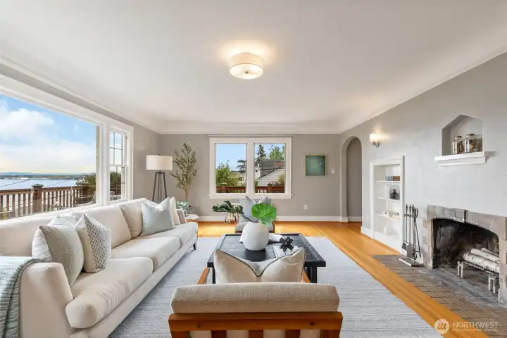 Generous living room with wood burning fireplace and large picture windows to frame the amazing views