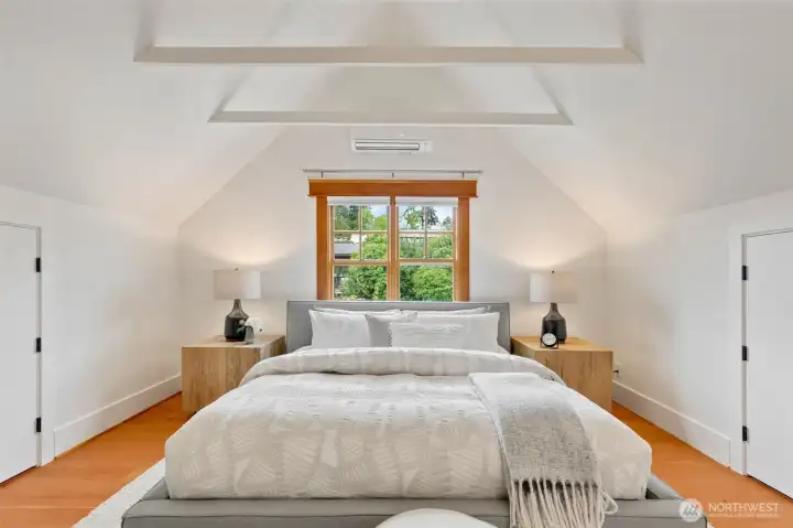 Spacious upstairs bedroom with vaulted ceilings and wide plank, tight grained, fir floors.