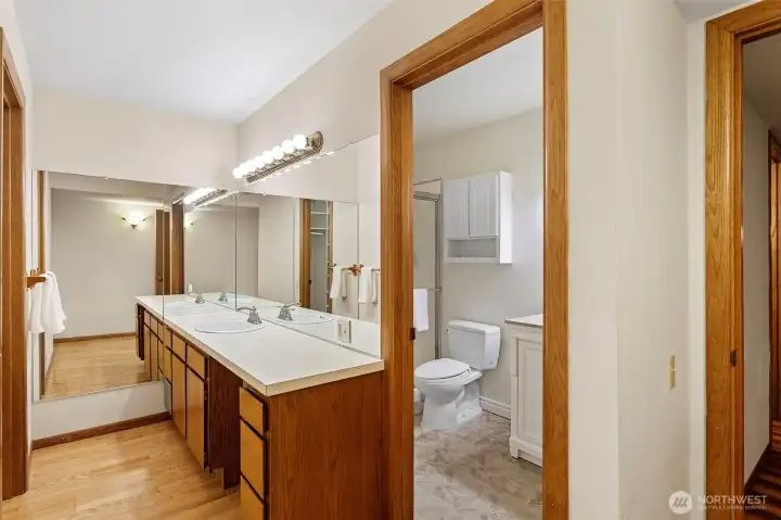 Primary bath has two vanities that are separated.