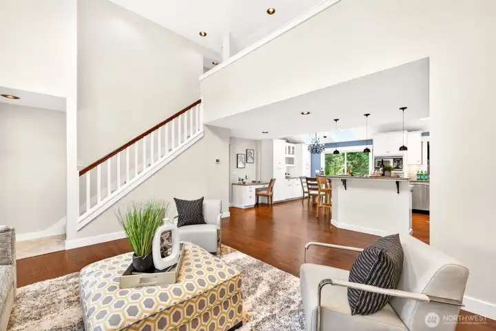 Refinished hardwoods carry the eye from the airy great room through to the open kitchen and dining areas, anchoring a connected floor plan tailored to modern living.