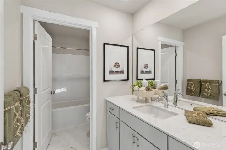 Full guest bathroom with quartz countertops, undermount sink and framed mirror. Photos are representative only and may display different color package and/or upgrades.