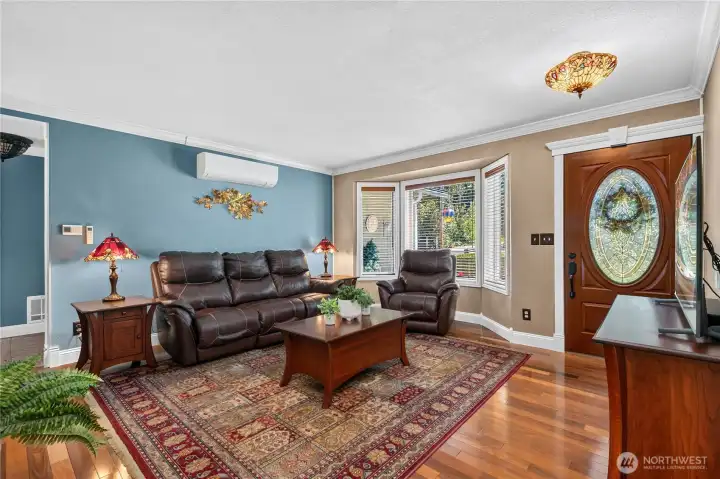 Living room with Brazilian hardwood floors, wood-wrapped windows, crown molding, ductless heating and AC, Tiffany lighting, and Levolor wood blinds. Living room with Brazilian hardwood floors, wood-wrapped windows, crown molding, ductless heating and AC, Tiffany lighting, and Levolor wood blinds.