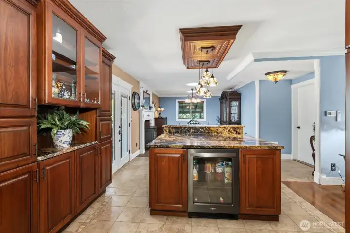 “Kitchen includes a beverage refrigerator, Tiffany island lighting, and ample storage space.” “Kitchen includes a beverage refrigerator, Tiffany island lighting, and ample storage space.”