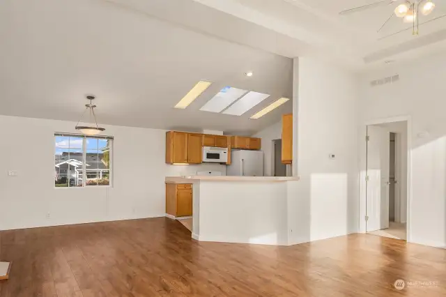 Looking towards the front of the home, the kitchen, and the door to the primary suite.