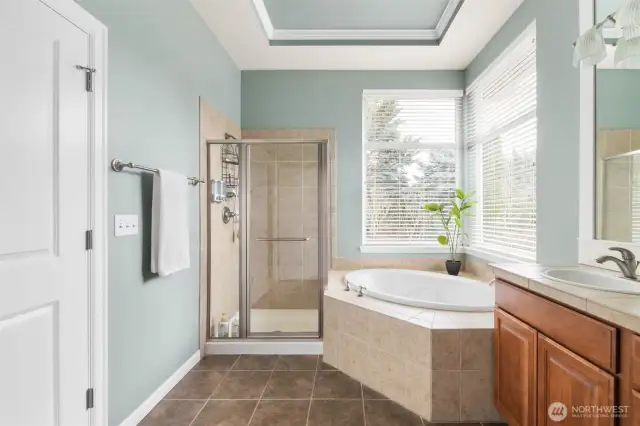 The spacious primary bathroom features a tiled corner tub, double sinks, and plenty of counter space for added convenience.