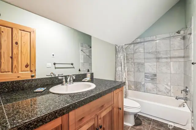 Upstairs full bathroom with granit counters and marble tile bath
