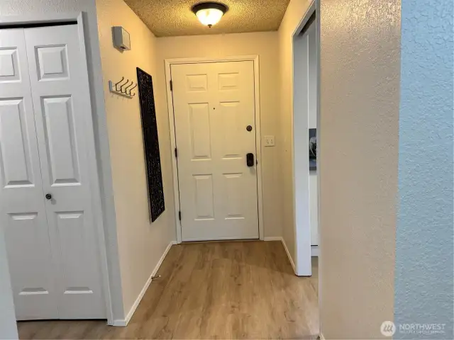 The front entryway has new vinyl plank flooring, a large coat closet and access to the kitchen and hall to bedrooms.