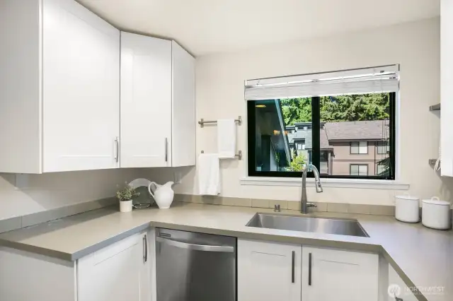 Beautiful quartz countertops in the recently renovated kitchen with large window.