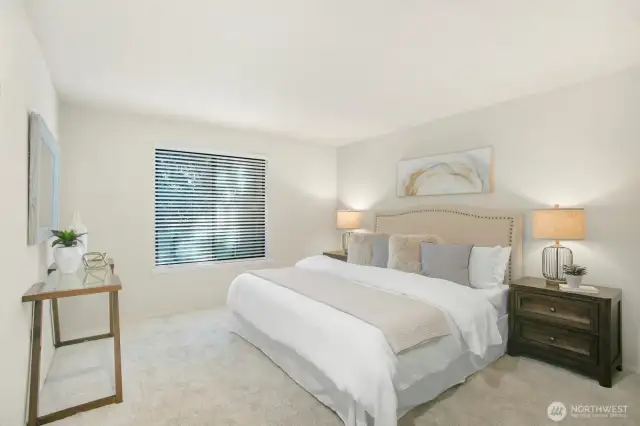 The spacious primary bedroom features a large window that fills the room with natural light—an inviting and comfortable retreat.