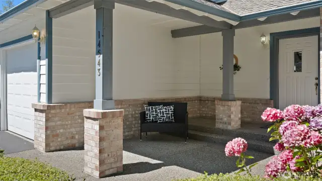 Hydrangeas burst into bloom across the property, framing a beautiful covered entry that’s spacious enough to welcome a crowd while keeping everyone sheltered from the elements.