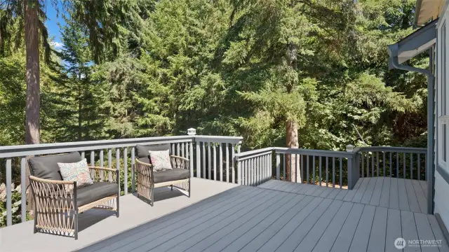 Behind you, a lush greenbelt provides a lovely forested view and a sense of serene seclusion.