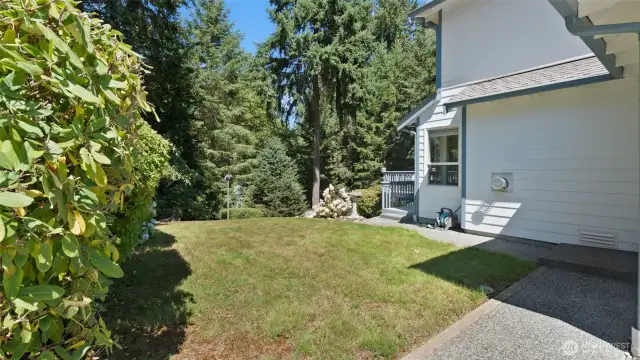 The side yard sits perfectly between the deck and the paved, gated parking area, adding convenience and versatile outdoor space.