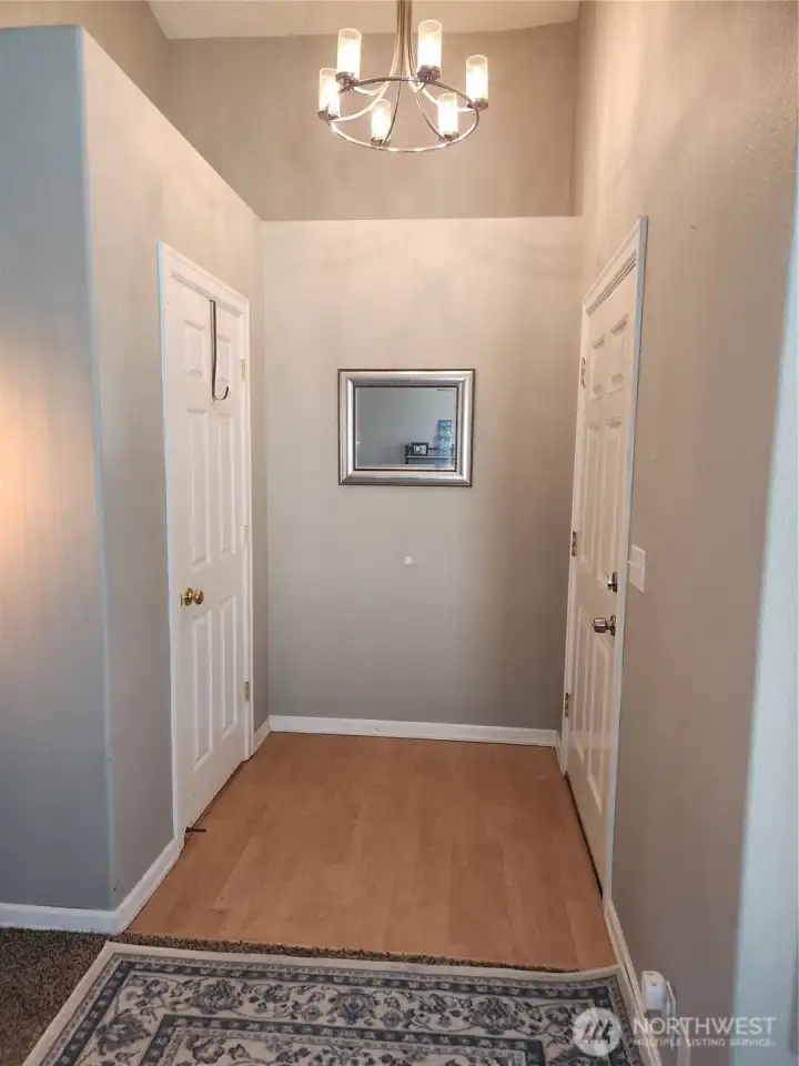 Entry into the home, wel lit and inviting. To the left is a coat closet door and the livingroom.