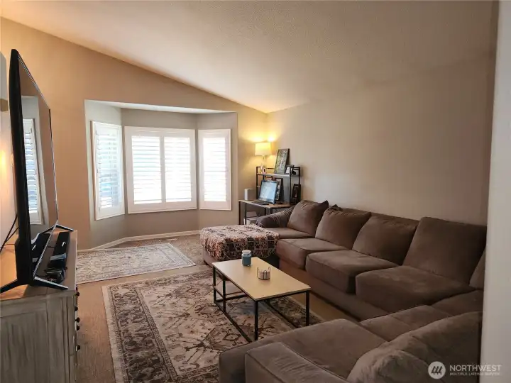 Vaulted ceilings with a bay window that looks out to the front yard.