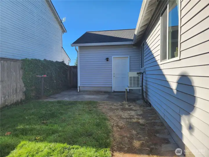 Side of the home, door leads to garage and HVAC unit in view.