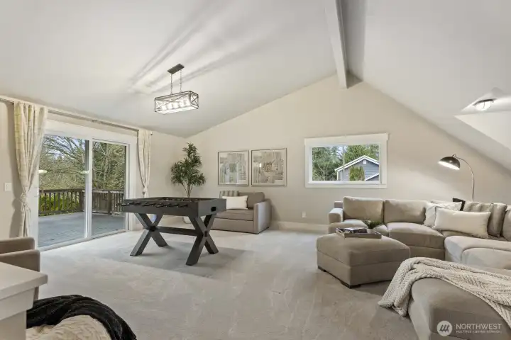 Another view of the bonus room that has access to the back deck and a second set of stairs leading to the lower level