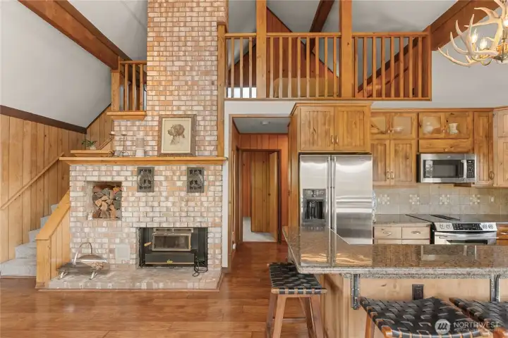 Custom woodwork throughout with alder fireplace mantel, railings, and wrapped wood columns and moldings.