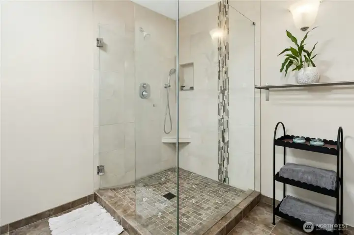 That walk-in shower isn't just a shower — it's a full reset at the end of a long day. The tile detail and built-in shelf say someone thought this through