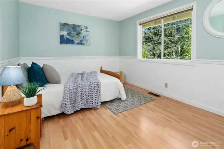 Waking up to treetop green views from this bedroom never gets old — nature as your morning wallpaper