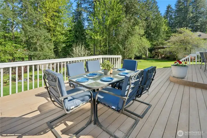 This deck was made for long summer evenings — wide enough for a full dining set with room to spare, and that backyard view seals the deal