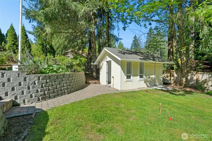 The detached structure with its stone retaining wall and dedicated pathway isn't an afterthought — it's a serious bonus. Workshop, studio, storage — the possibilities are real.