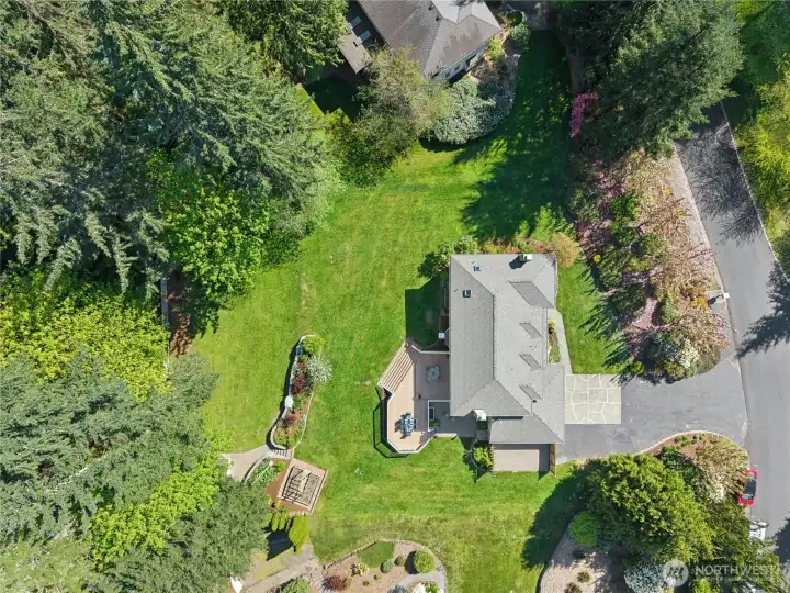 From above you can see what the ground photos can only hint at — the deck, the garden, the outbuilding, and all that flat green space working together. This yard has a plan and it shows
