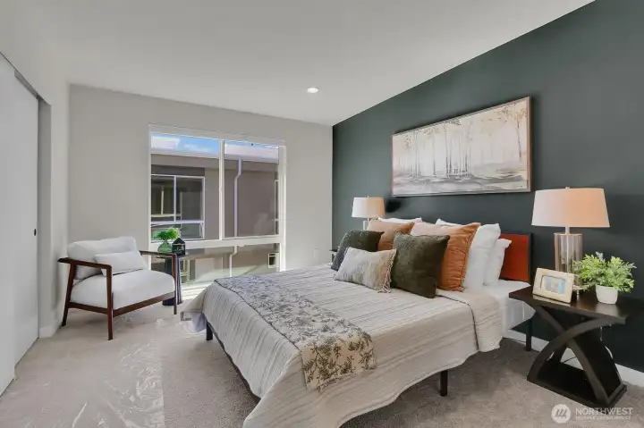 The upper level Primary bedroom has a floor-to-ceiling window that floods the room with light, as well as a walk-in closet and access to the shared bath.