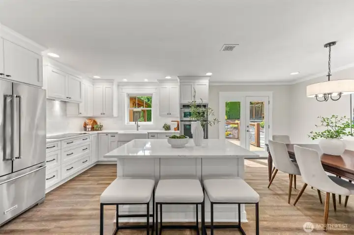 Chefs kitchen with custom cabinetry, quartz counters and an island